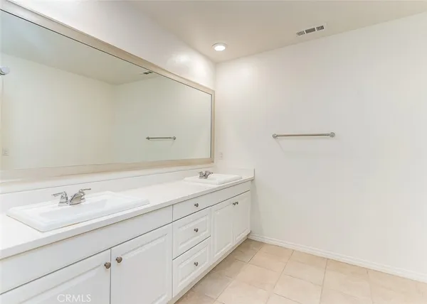 a bathroom with a double vanity sink and a mirror