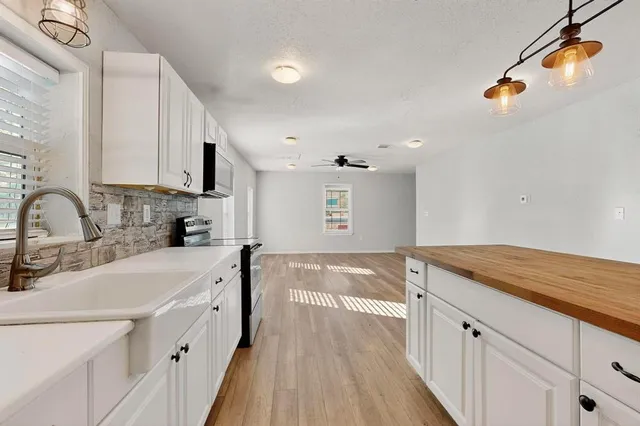 a kitchen with kitchen island granite countertop a sink and cabinets