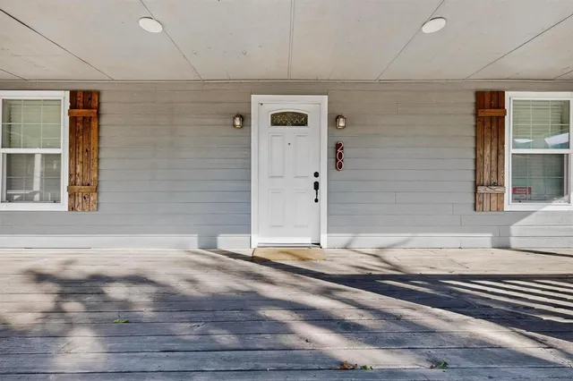 a view of empty room with wooden floor and window