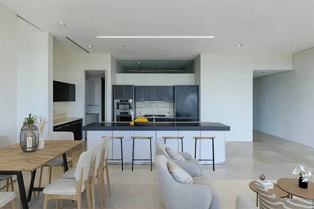 a kitchen with stainless steel appliances a sink a stove a table and chairs