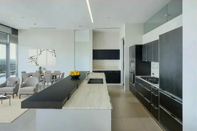 a large kitchen with stainless steel appliances a large counter top a stove and a refrigerator