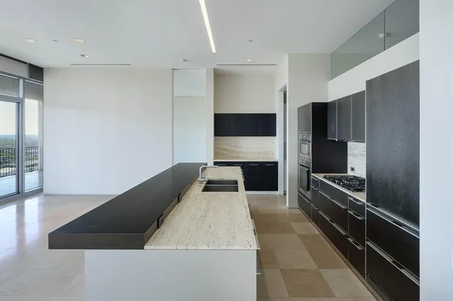 a large kitchen with a large counter top stainless steel appliances and cabinets