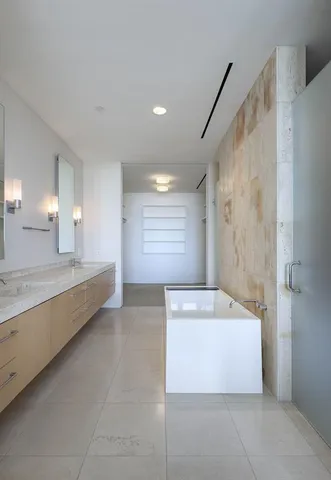 a large spacious bathroom with a large tub shower and checkered floor