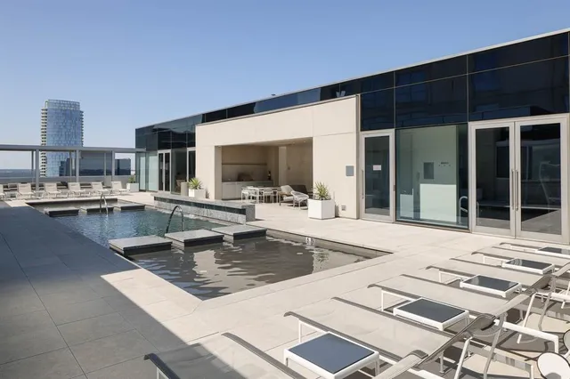 a swimming pool view with a seating space