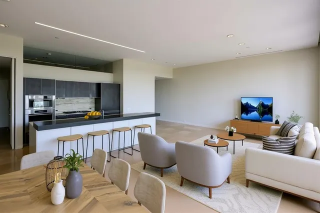 a living room with furniture and kitchen view