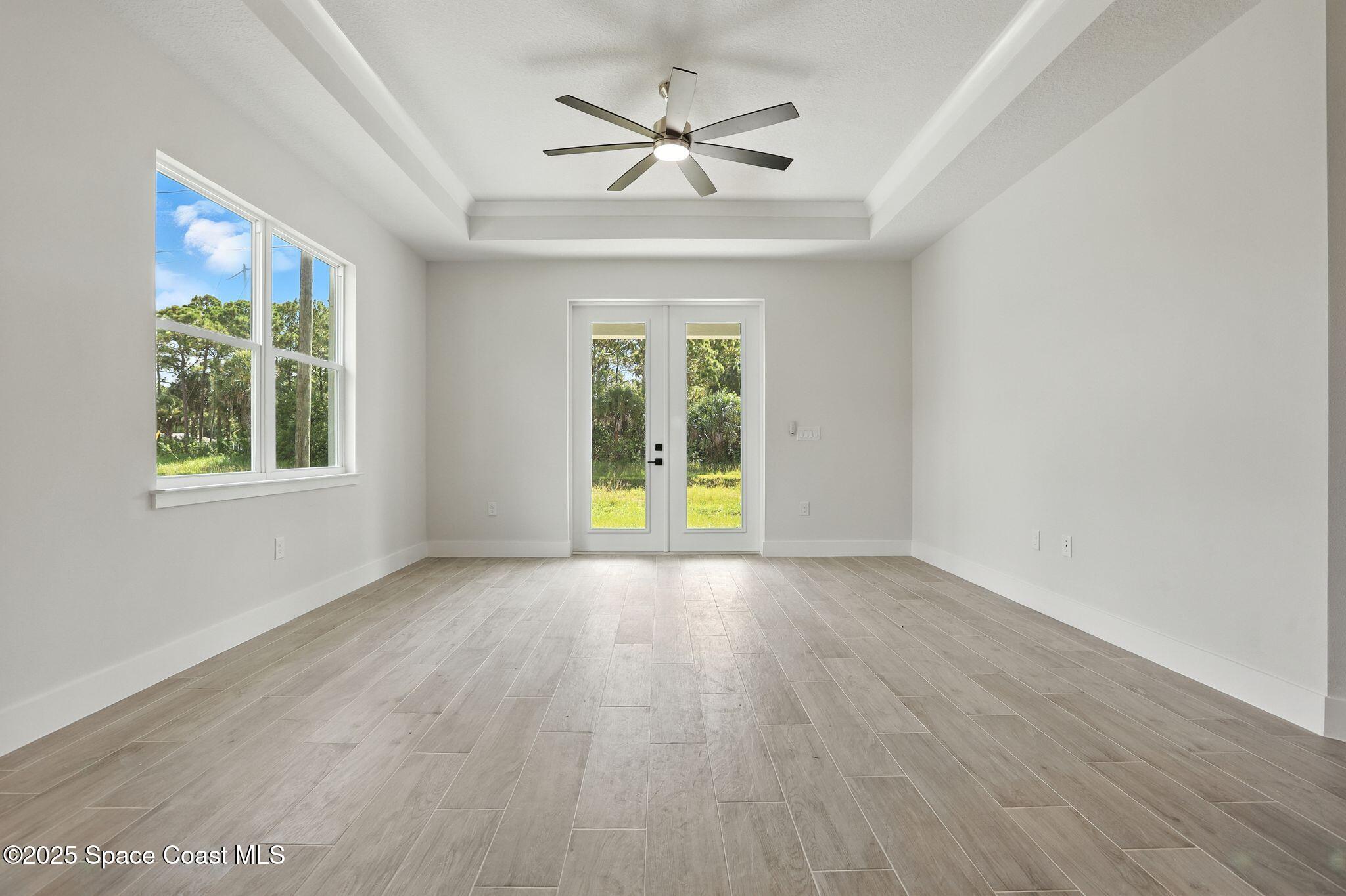 475 Flagler Road Southeast Palm Bay, FL 32909 - Photo 12 of 30 an empty room with wooden floor and windows