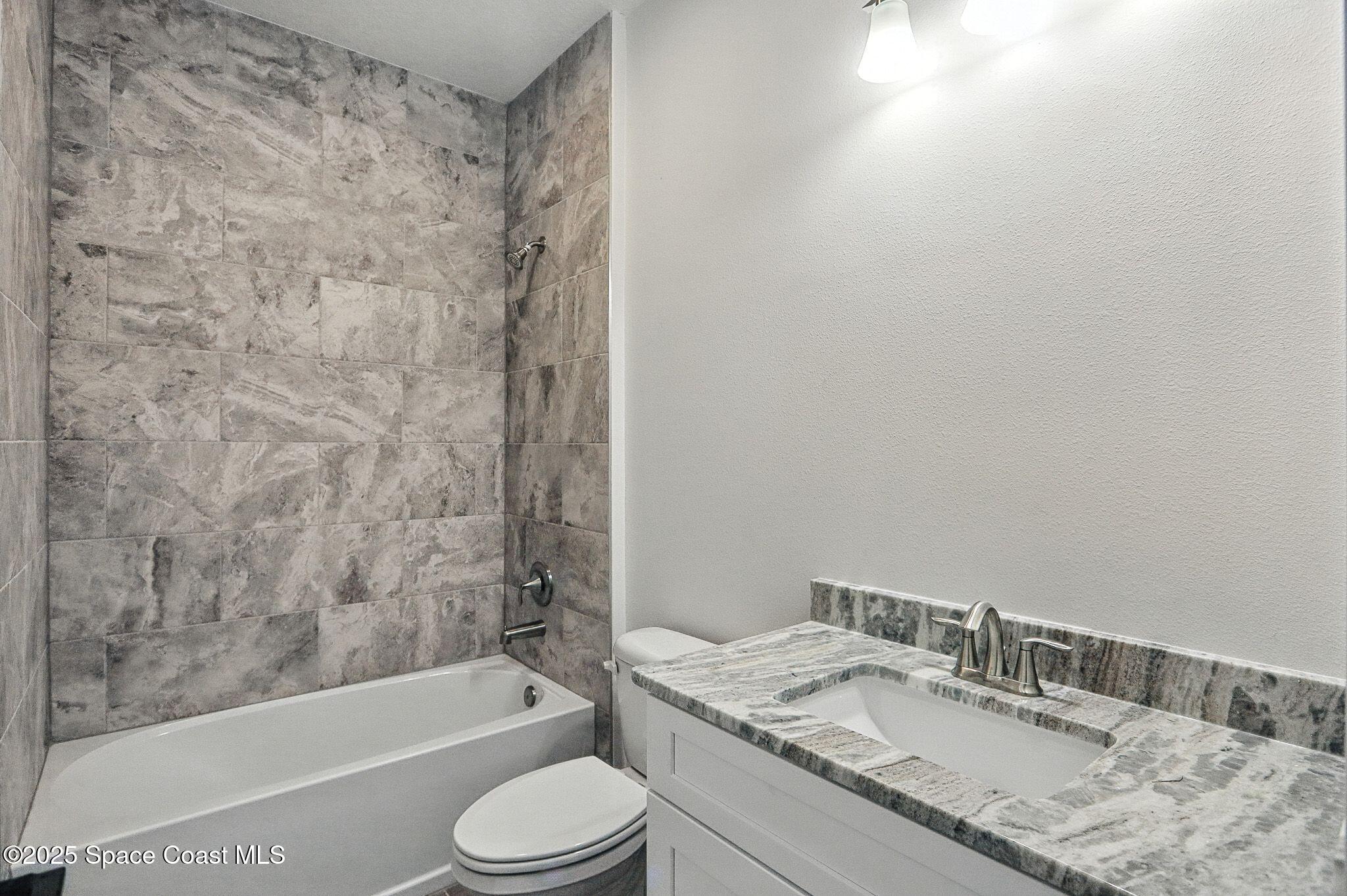 475 Flagler Road Southeast Palm Bay, FL 32909 - Photo 21 of 30 a bathroom with a granite countertop sink toilet and bathtub