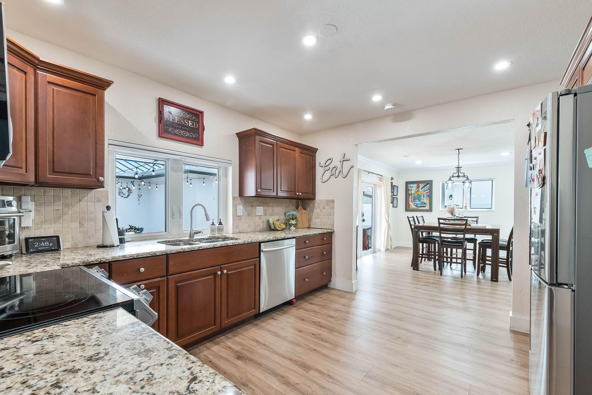6231 Southwest 94th Avenue Miami, FL 33173 - Photo 14 of 47 a kitchen with stainless steel appliances granite countertop wooden cabinets a dining table and chairs