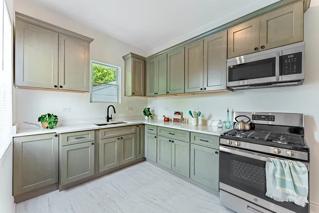 a kitchen with stainless steel appliances granite countertop a sink stove and microwave