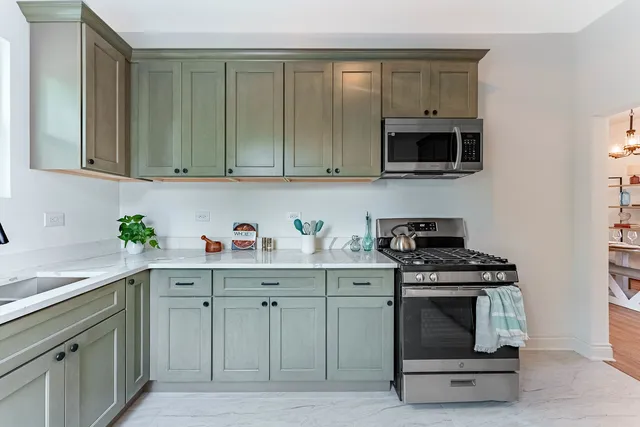 a kitchen with stainless steel appliances granite countertop a stove a sink and a microwave