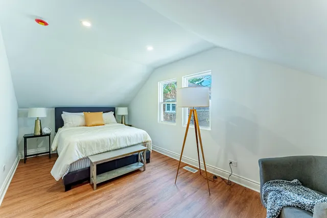 a bedroom with a bed and wooden floor