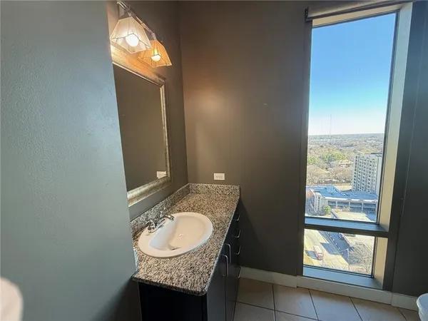 a bathroom with a granite countertop sink and a mirror