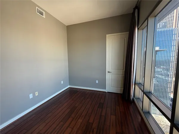 a view of a room with wooden floor and a window