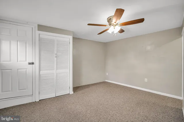 an empty room with closet and fan
