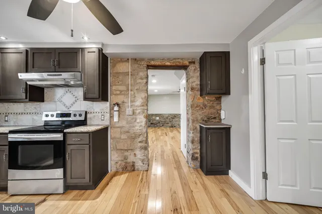 a kitchen with stainless steel appliances kitchen island granite countertop a stove a sink and a refrigerator