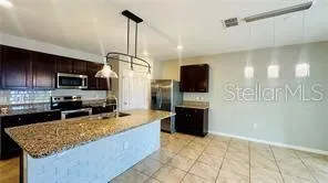 a kitchen with stainless steel appliances granite countertop a stove refrigerator and microwave