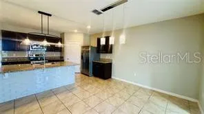 a kitchen with stainless steel appliances granite countertop a refrigerator a oven a sink and a counter top