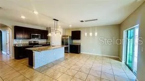a kitchen with stainless steel appliances granite countertop a refrigerator and a stove top oven