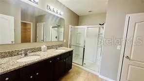 a bathroom with a granite countertop sink a mirror and a shower