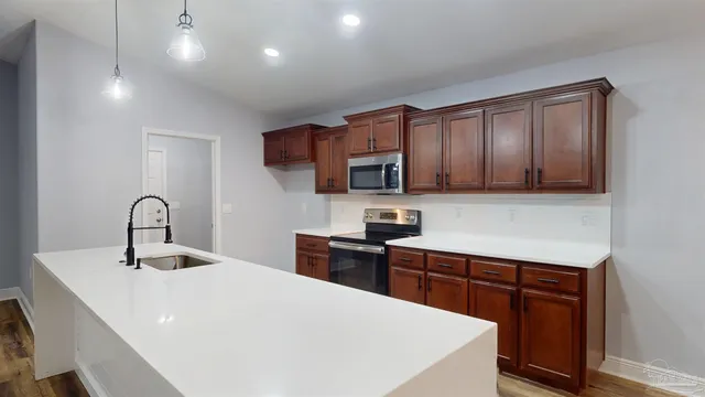 a kitchen with stainless steel appliances granite countertop a sink a kitchen island with wooden floors and floors