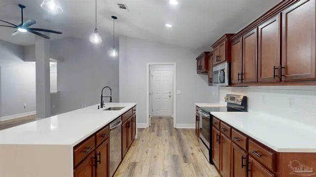 a kitchen with stainless steel appliances granite countertop a sink a stove and a refrigerator