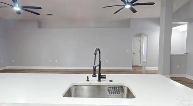 a living room with furniture a flat screen tv and kitchen view