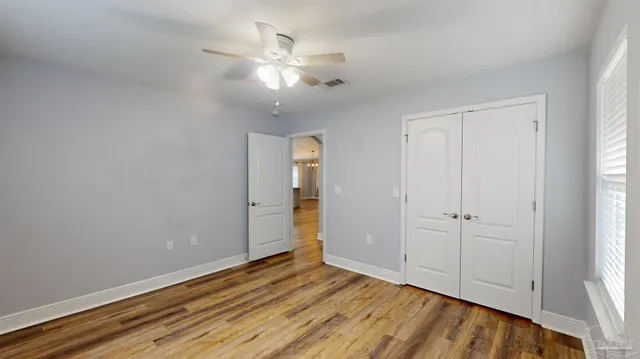 a view of empty room with wooden floor