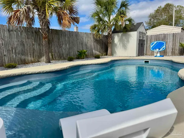 a view of house with swimming pool and furniture