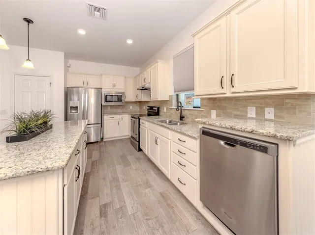 a kitchen with sink stove and cabinets