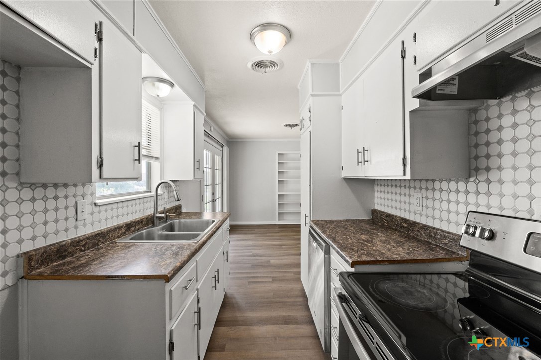 1401 Stephen Street Killeen, TX 76549 - Photo 11 of 27 a kitchen with granite countertop a sink stove and cabinets