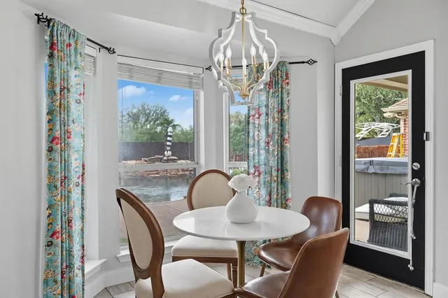 a dining room with furniture a chandelier and window