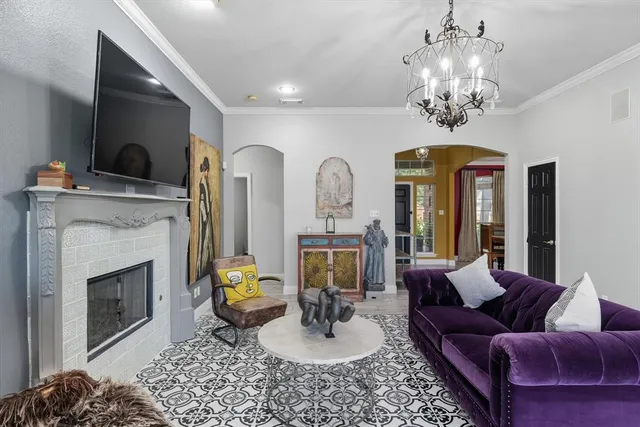 a living room with furniture a fireplace and a chandelier