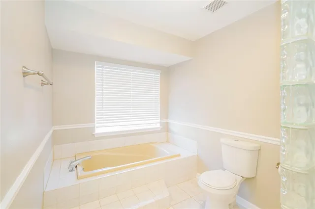 a bathroom with a bathtub shower and toilet
