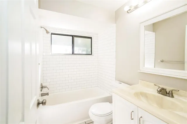 a bathroom with a bathtub shower sink vanity and toilet