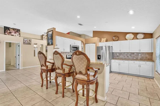 a kitchen with stainless steel appliances granite countertop a refrigerator and a stove top oven
