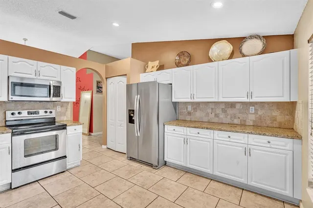 a kitchen with stainless steel appliances granite countertop a sink and cabinets