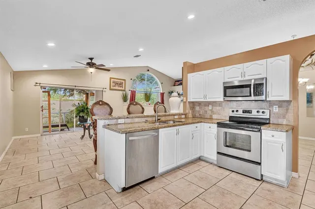 a kitchen with stainless steel appliances granite countertop a refrigerator and a sink