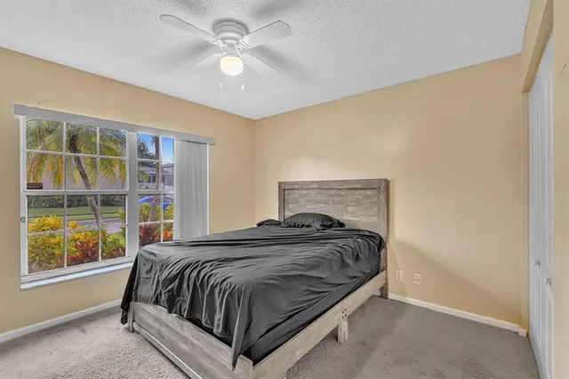 a bedroom with a bed and a ceiling fan