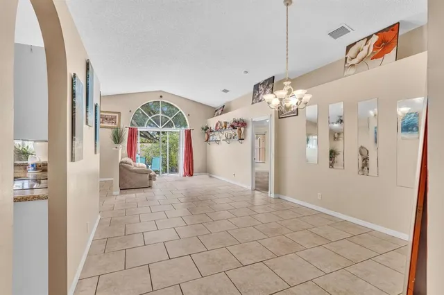 a view of a hallway with windows and chandelier