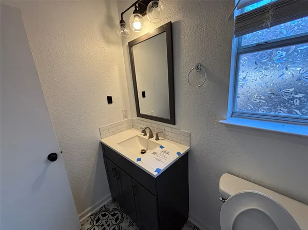 a bathroom with a toilet sink and mirror