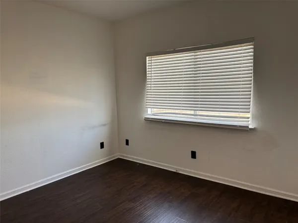 an empty room with wooden floor and a window