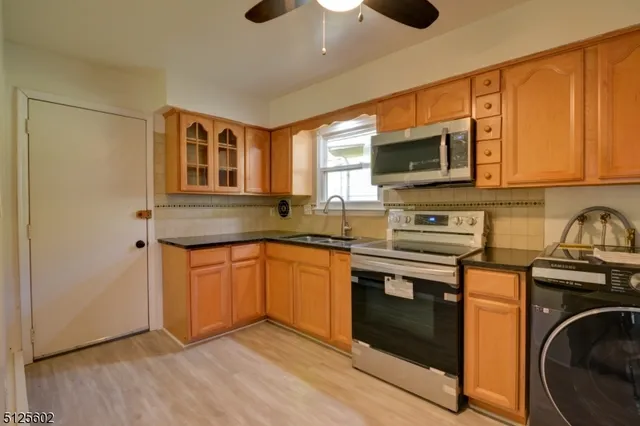 a kitchen with stainless steel appliances granite countertop a stove a sink and a microwave