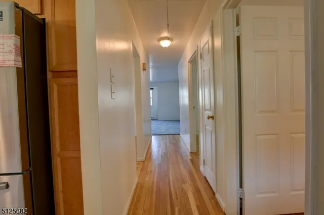 a view of a hallway with wooden floor
