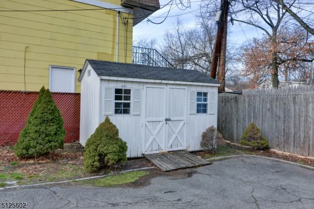 a view of a house with backyard and trees