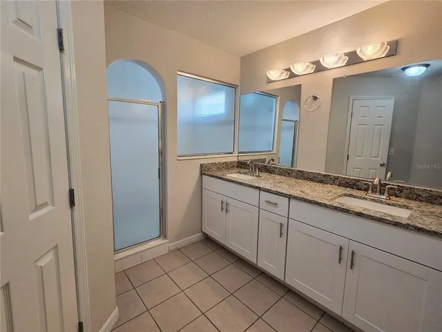 a spacious bathroom with a granite countertop sink and mirror