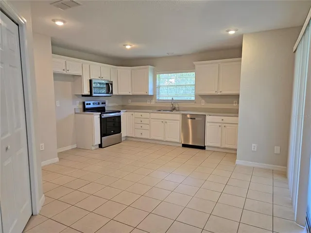 a kitchen with stainless steel appliances granite countertop a sink and cabinets