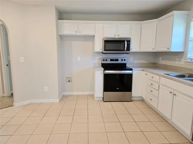 a kitchen with a stove top oven and cabinets