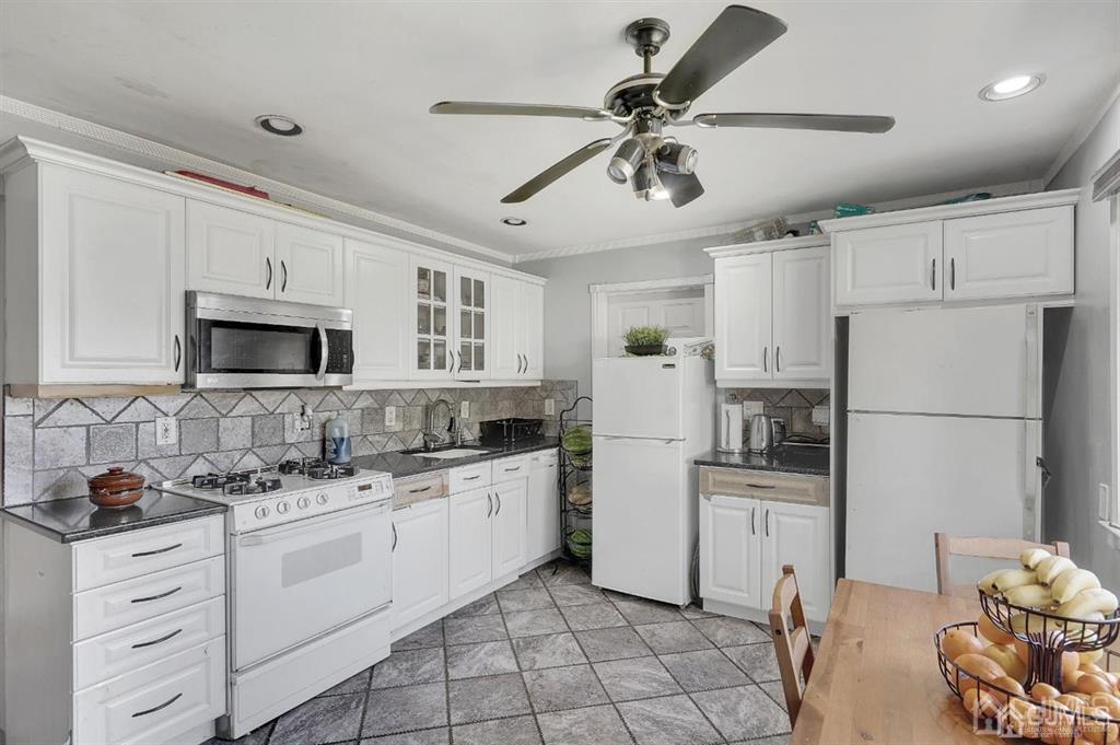 141 Winthrop Road Edison, NJ 08817 - Photo 12 of 30 a kitchen with white cabinets and appliances