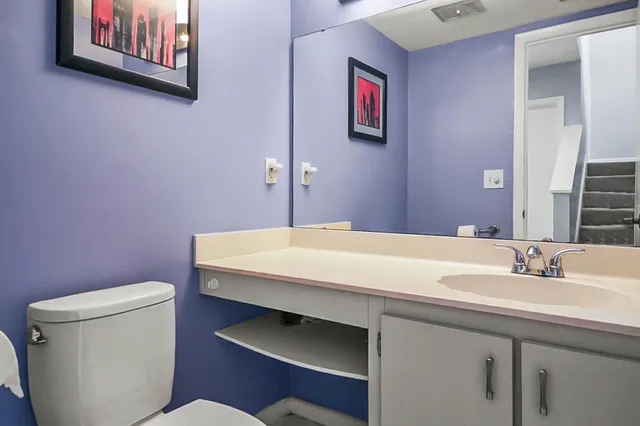 a bathroom with a sink a toilet and mirror