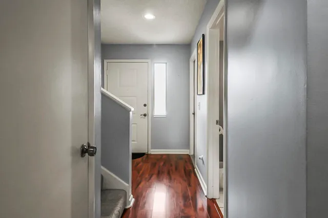 a view of a hallway with wooden floor